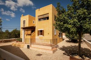 a brick building with a tree in front of it at Can Noves - Villa de 5 suites 28 y 58 in Sant Francesc Xavier