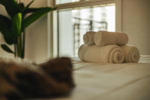 a pile of towels sitting on top of a bed at Voyage's Stylish 1br At Waters Edge in Abu Dhabi