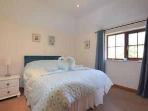 East Harling的住宿－2 Bed in Thetford 64075，卧室配有一张床上的2个天鹅