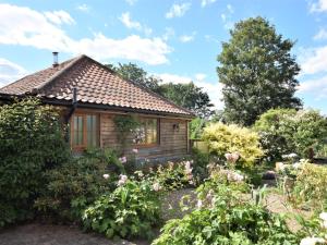 a cottage in the garden with flowers at 2 Bed in Thetford 64075 in East Harling