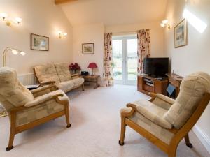 a living room with two chairs and a television at 2 Bed in Harrogate District HH087 in Stainburn