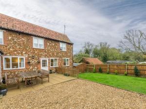 a brick house with a patio and a yard at 3 bed property in Sedgeford KT092 in Sedgeford