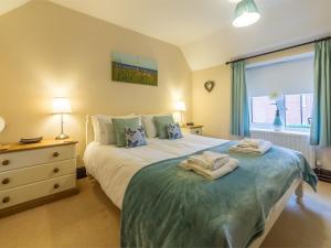 a bedroom with a bed with two towels on it at 3 bed property in Sedgeford KT092 in Sedgeford