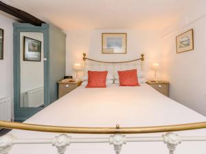 a bedroom with a large bed with two red pillows at 1 Bed in Tenterden 66342 in Tenterden