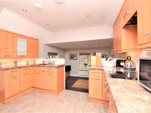 a large kitchen with wooden cabinets and appliances at 1 Bed in Cley NCC04 in Cley next the Sea