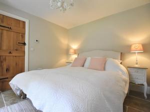 een slaapkamer met een groot wit bed met roze kussens bij 1 Bed in Whorlton G0121 