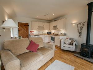 a living room with a couch and a stove at 1 bed in Bedale G0094 in Crakehall