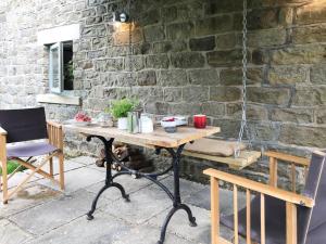 a table and chairs in front of a stone wall at 1 Bed in Goathland G0140 in Goathland