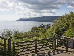 a wooden fence on a hill next to a body of water at 2 Bed in Robin Hoods Bay G0085 in Robin Hood's Bay