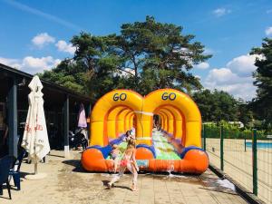 a group of people playing in an inflatable water park at Safaritent at Camping GT Keiheuvel in Balen