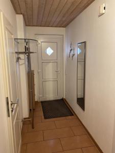 einen Flur mit Dusche und eine Tür mit Spiegel in der Unterkunft Ferienwohnung Kajüte 19 in Greetsiel