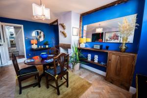 een eetkamer met blauwe muren en een tafel en stoelen bij 72 - Quirky One Bed Property in the Norwich Lanes in Norwich