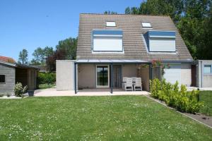 ein Haus mit einem Rasen davor in der Unterkunft Lamsoor 26* in Nieuwvliet