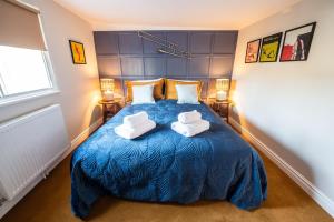 een slaapkamer met een blauw bed en 2 witte stoelen bij 72 - Quirky One Bed Property in the Norwich Lanes in Norwich