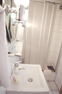 a bathroom with a white sink and a shower at Pension Am Alten Markt in Halle an der Saale +10 photos
