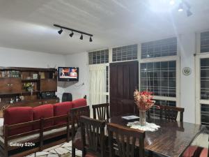 耶爾瓦布埃納的住宿－Casa Al pie del Cerro，一间带桌子和红色椅子的用餐室