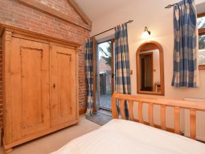 a bedroom with a bed and a brick wall at 1 Bed in Lincoln 73852 in East Barkwith