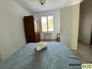 Un dormitorio con una cama con una toalla blanca. en Version SUD Lumineuse Bas Maison avec jardin, en Toulon