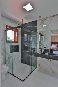 uma casa de banho com uma cabina de duche em vidro e um WC. em La Vie Pousada de Charme em Campos do Jordão