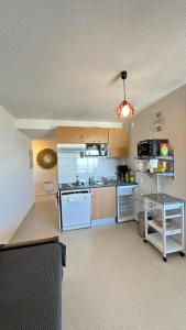 uma cozinha com electrodomésticos brancos e uma mesa em Résidence Les Balcons du Pic d'Anie em Arette