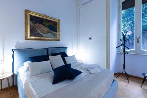 a bedroom with a white bed with blue pillows at Antonelli Place in Rome