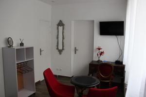 a living room with a table and red chairs at PARIS de FLORE Stane in Malakoff