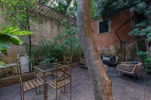a group of chairs and a tree next to a building at Antonelli Place in Rome