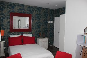 a bedroom with a bed with red pillows at PARIS de FLORE Stane in Malakoff