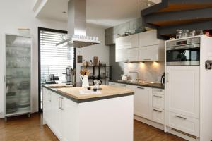 a kitchen with white cabinets and a white refrigerator at Kreatives Studio mit Galerie in Nottuln