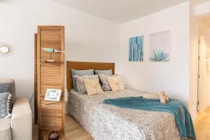 Un dormitorio con una cama con almohadas. en La Palometa en Torre del Mar