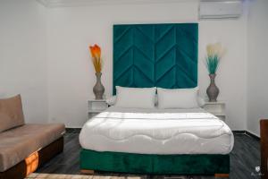 - une chambre avec un grand lit et un canapé dans l'établissement DAR BLANCA, à Chefchaouen