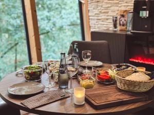 a wooden table with food and wine glasses on it at Tree Inn - Das Baumhaushotel in Dörverden