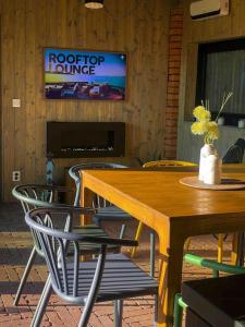 mesa de madera con sillas y TV en la pared en StodolA MorávkA en Morávka