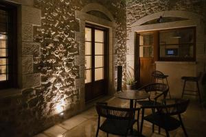 a room with a table and chairs and a wall at Μikri Arktos Boutique Hotel in Dhimitsana
