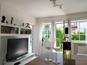 a living room with a bottle of wine and two wine glasses at Villa Schaller - Apartment in Krumpendorf am Wörthersee