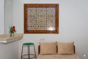 a window in a room with a couch and a stool at DAR BLANCA in Chefchaouene