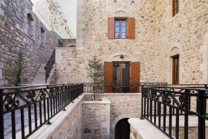 an external view of a building with a black railing at Μikri Arktos Boutique Hotel in Dhimitsana