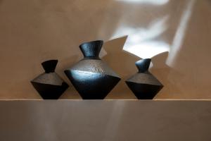 three black vases sitting on top of a shelf at Μikri Arktos Boutique Hotel in Dhimitsana