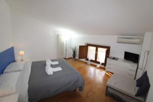 西恩納的住宿－拉瑞撒利塔公寓，一间卧室配有一张带两条白色毛巾的床