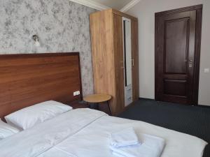 a bedroom with a bed with a wooden headboard and a door at City Club European in Chernivtsi