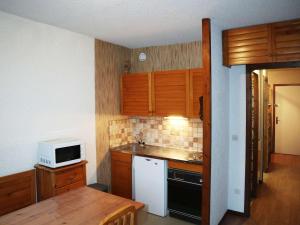 uma cozinha com armários de madeira e um micro-ondas branco em Appartement Les Orres, 1 pièce, 4 personnes - FR-1-322-122 em Les Orres