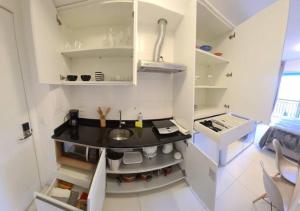 a small white kitchen with a sink in it at Wize in Sao Paulo