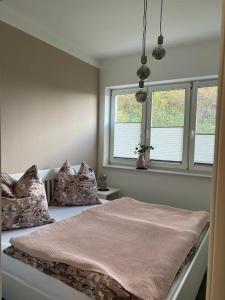 a bedroom with two beds and two windows at Ferienhaus Elgersburg in Elgersburg