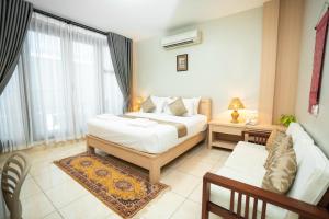 Un dormitorio con una cama, un sofá y una mesa. en Vongkhamsene Boutique Hotel, en Ban Nongdouang 58 fotos más