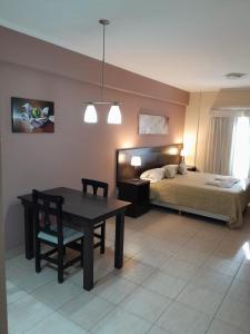 1 dormitorio con 1 cama, mesa y silla en Antares Apartments en Campana