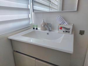 a white sink in a bathroom with a mirror at Paradise in haifa near the bahai gardens in Haifa