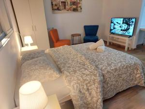 a bedroom with a bed and a tv and chairs at Paradise in haifa near the bahai gardens in Haifa
