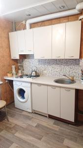 een keuken met een wastafel en een wasmachine bij Квартира у метро Спортивная in Charkov