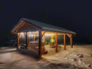 a wooden gazebo in the snow at night at Lackowa Chill and Rest domki z balią Krynica Zdrój in Krynica Zdrój