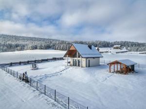 a small house in the snow with a fence at Lackowa Chill and Rest dom z balią in Uście Gorlickie